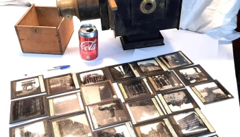 Antiguo proyector de chapa y bronce con muchas diapositivas en vidrio
