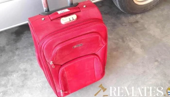 balija de equipaje roja con ruedas