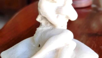 Figura marmolina mujer joven sentada